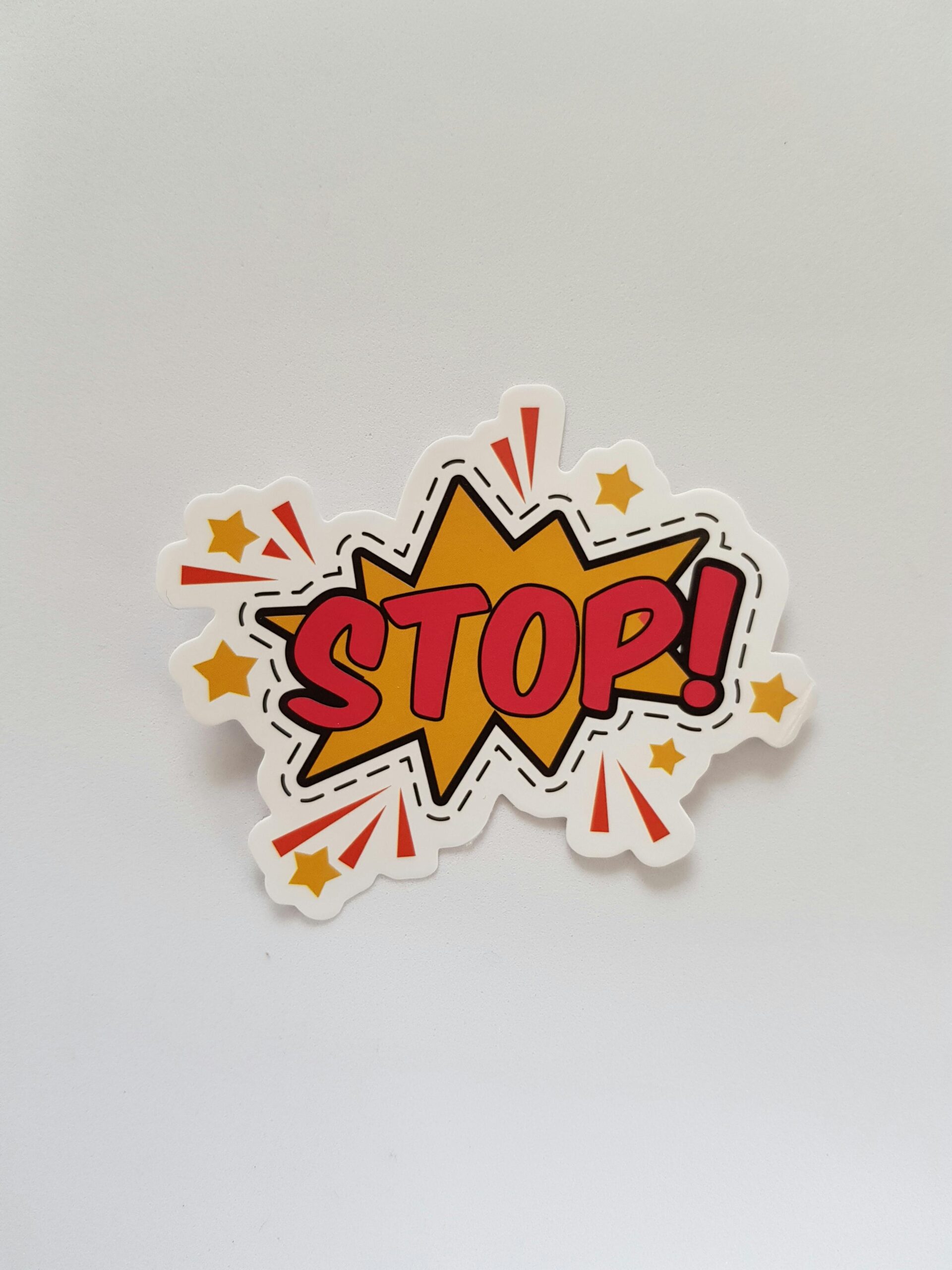 Bright and colorful sticker design featuring a comic-style 'Stop!' sign on a gray background.